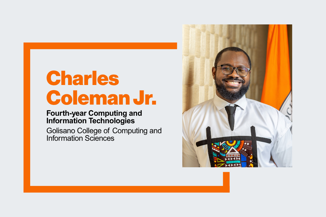 Headshot of Charles Coleman Jr. He is smiling and standing infront of an RIT flag.